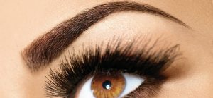 Close-up eines Auges mit dichten, gehobenen Wimpern.
